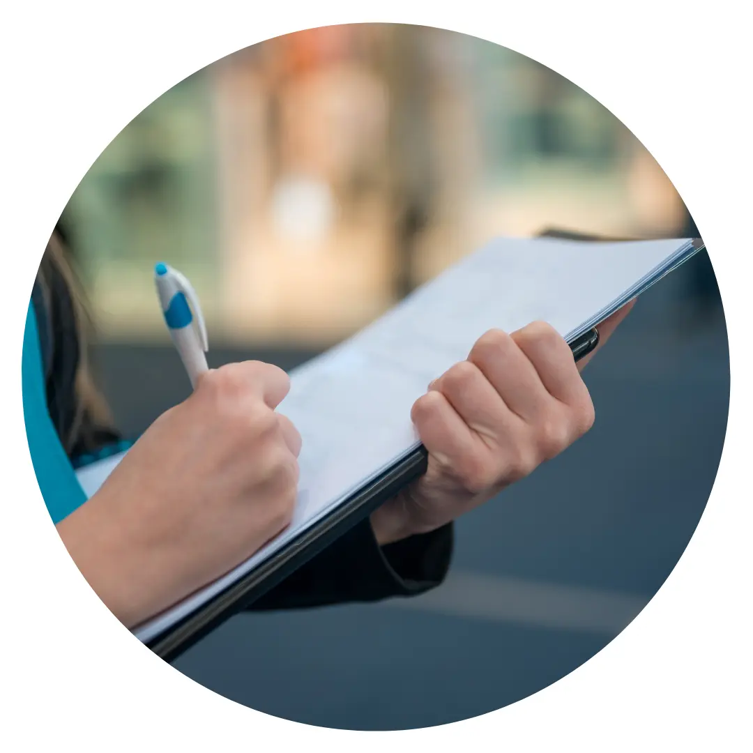 A person filling in a form on a clipboard