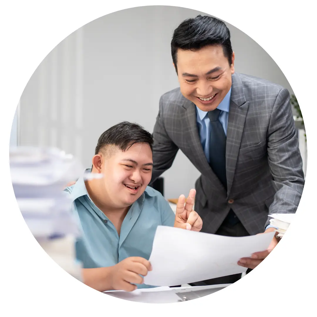 A man in a suit and a young man looking over documents together
