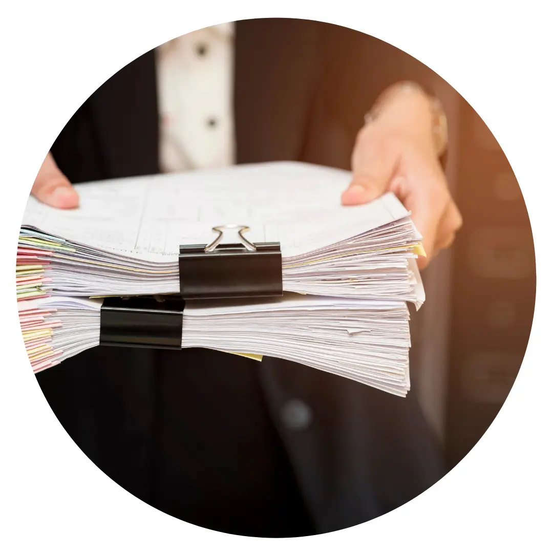 Hands holding a bundle of documents held together with a clip