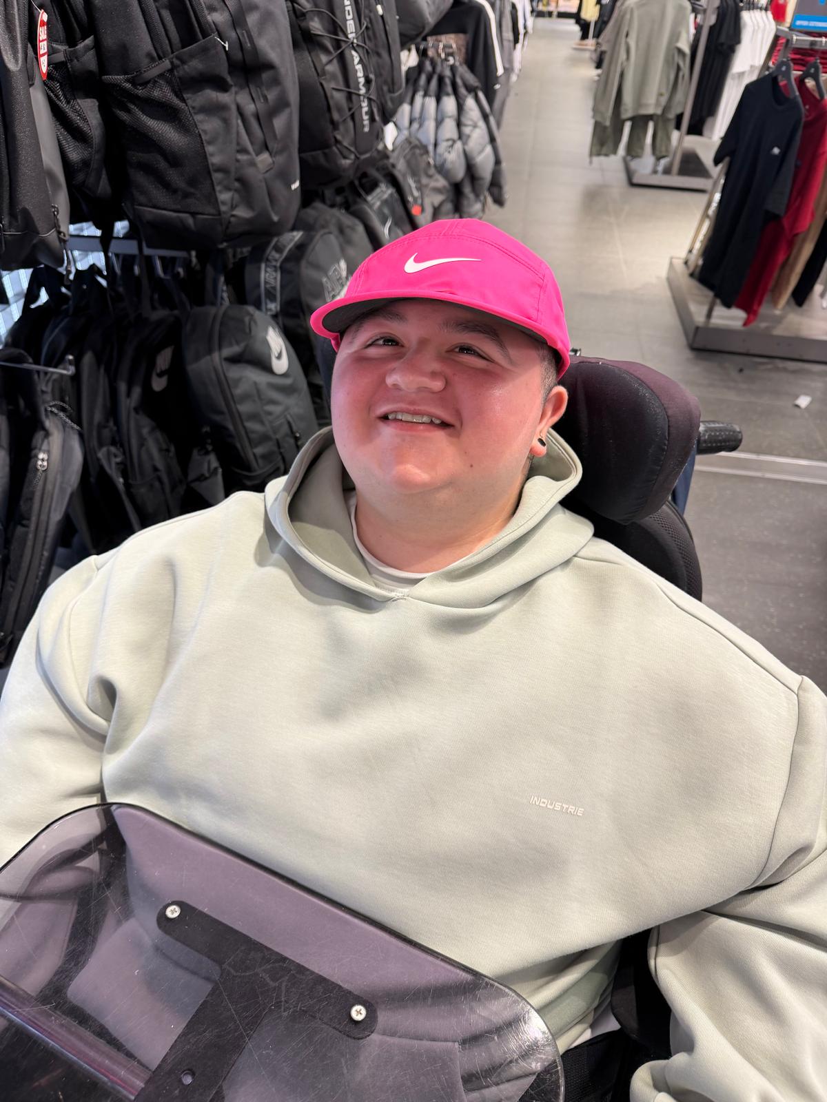 A Yours Truly participant in a pink cap, smiling on a shopping trip
